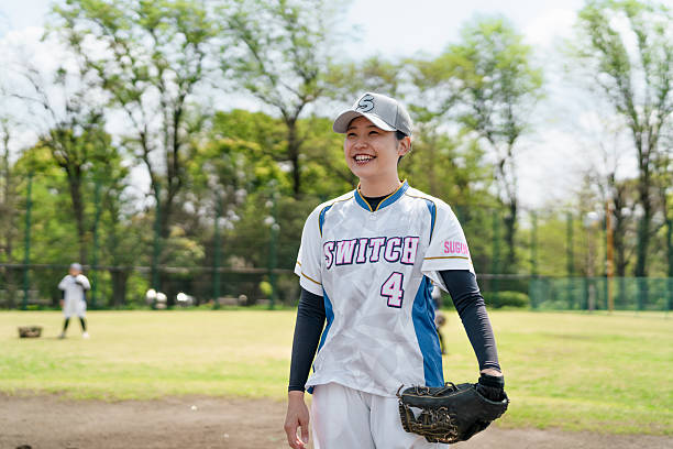 istock Female Softball Player Smiling During Practice on Open Suburban Field 2214715261