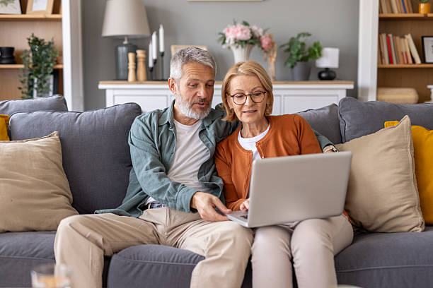 istock Couple Sharing Laptop Experience Together on Couch 2214717014