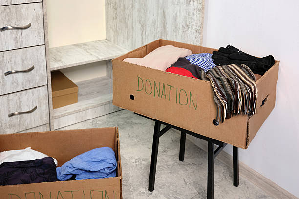 istock Close-up a several a cardboard donation boxes with things, with an empty clothes closet in the background. Help for poor and needy people. 2214719733