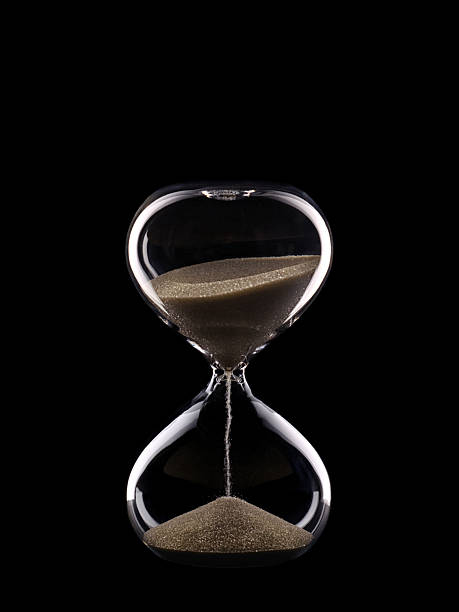 istock Glass hourglass isolated on black background. 2214720465