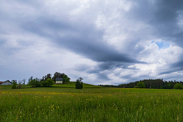 istock Cozy house on a hill under clouds 2214723642
