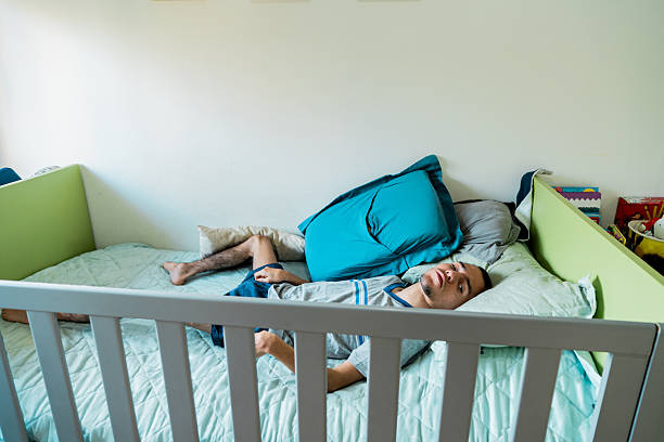 istock Young man with mental illness lying down at home 2214725110