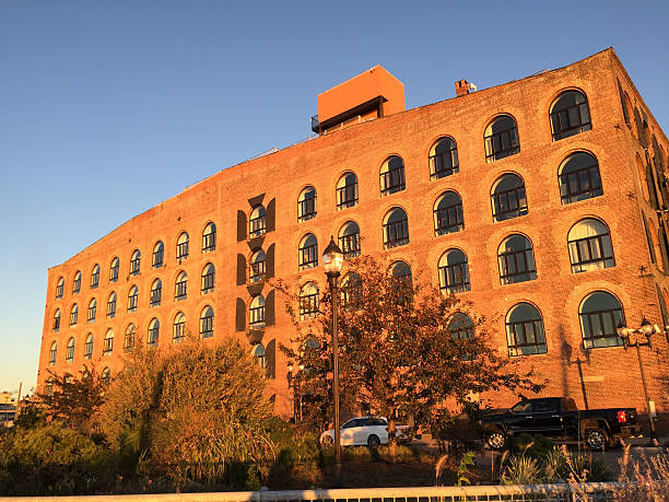 istock Old red brick warehouse with arched windows in late afternoon sunlight 2214726372