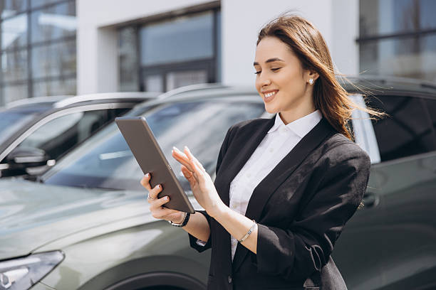 istock Saleswoman using tablet and working at car dealership 2214727021