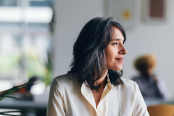 istock Confident Middle-Aged Woman in Business Attire Posing in a Bright Workspace 2214727152