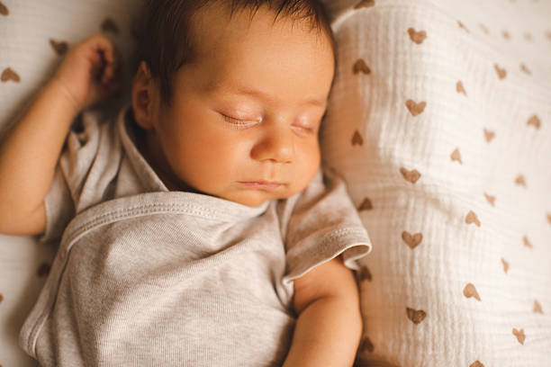 istock Cute baby boy sleeping in bed 2214727924