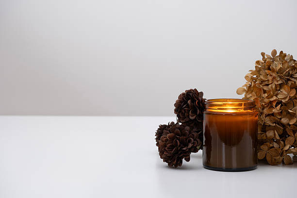 istock A burning amber glass candle in a cozy setting with dried hydrangeas and mini chrysanthemums. 2214729495