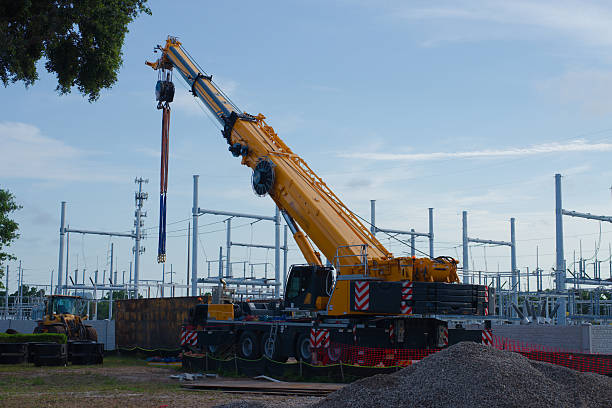 istock Large Yellow Crane Operating at an Outdoor Construction Site under Clear Sky 2214729681