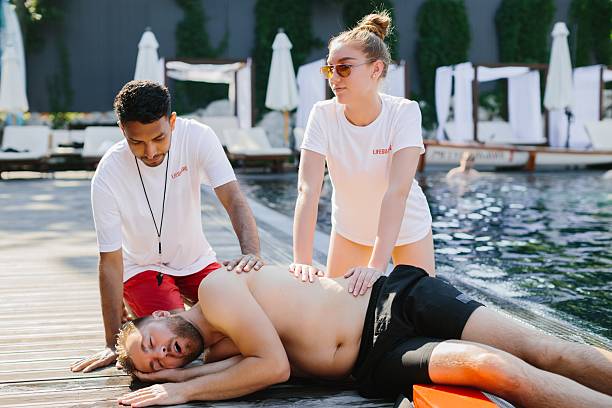 istock Lifeguards performing cpr on unconscious swimmer by poolside 2214733069