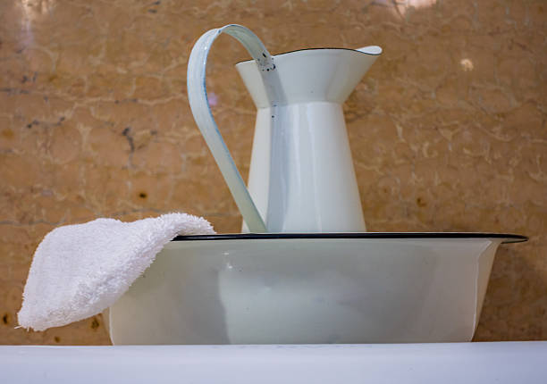 istock Ceramic pitcher and bowl in a bathroom setting with a towel displayed on the edge 2214736691
