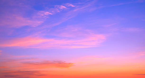istock Evening sky background with colorful orange and pink sunlight clouds on beautiful romantic blue sunset sky 2214739784