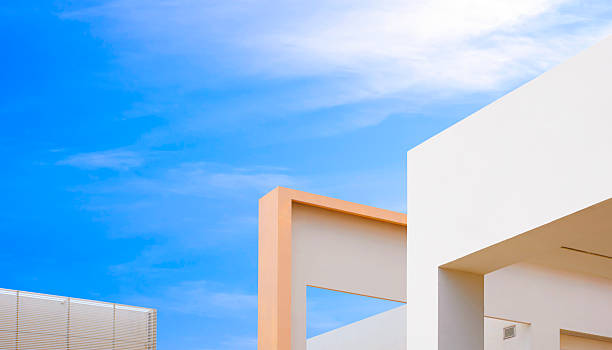 istock Building exterior geometric architecture design. Abstract geometric beige concrete wall of office facade against blue sky background in minimal style 2214739888