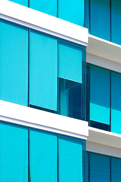 istock Modern office building with blue roller sun blinds inside of glass wall in vertical frame, exterior architecture background in minimal style 2214739895