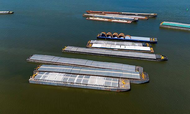 A barge, flat-bottomed boat, pushed by tugboat along the river for transportation, high angle view