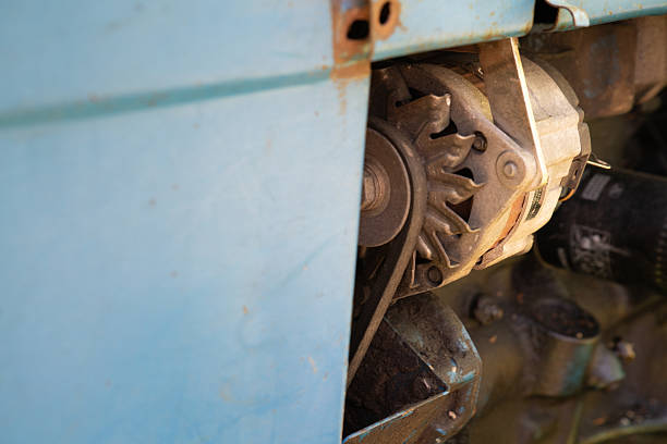 In a workshop filled with tools, a close-up reveals an engine component showing signs of wear. The light highlights the mechanical details and textures present on the part.