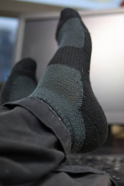 istock Cozy feet in patterned socks resting on desk. 2214747047