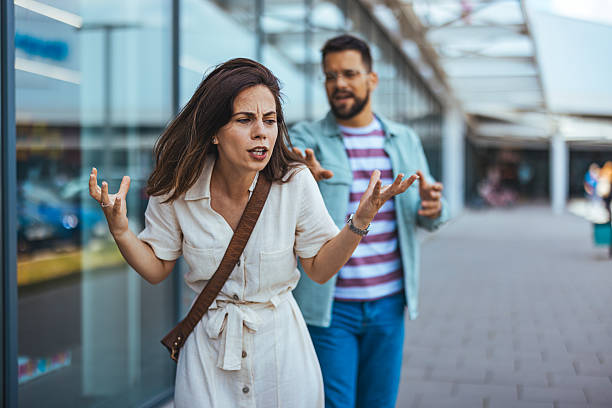 Couple in Argument While Walking Along an Urban Shopping Area