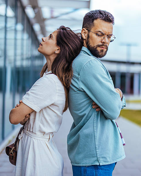 istock Conflicted Couple Standing Back to Back in Outdoor Modern Setting 2214750866