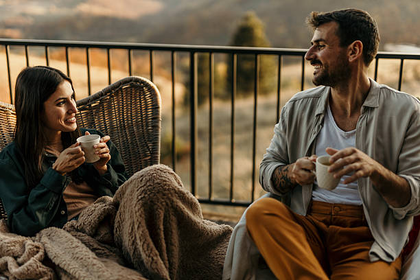 istock Young couple relaxing on balcony, enjoying coffee and scenic view 2214752043