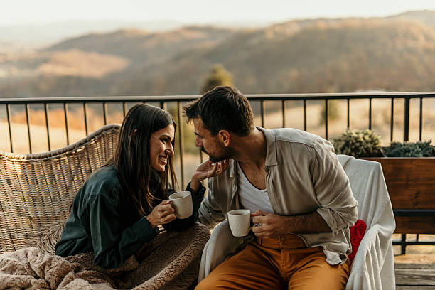 istock Romantic couple enjoying coffee on balcony with scenic view 2214752091