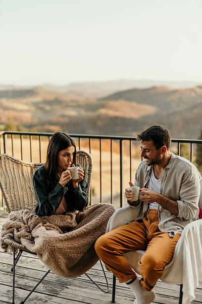 istock Couple enjoying hot drinks on balcony overlooking scenic mountains 2214752120