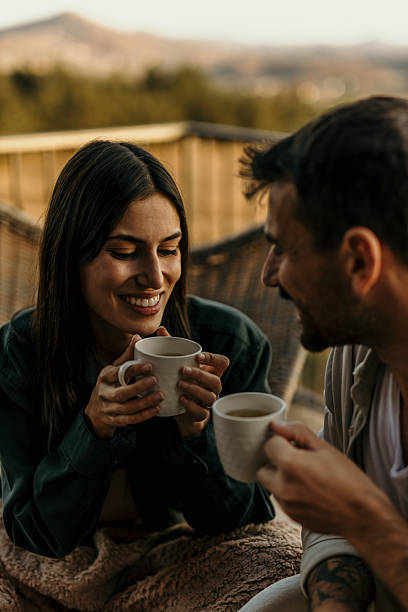 istock Young couple sharing a moment of intimacy while enjoying hot drinks on a balcony 2214752178