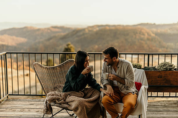 Couple enjoying coffee and scenic view from balcony