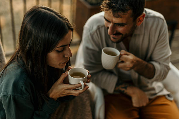 istock Young couple relaxing and drinking tea on balcony 2214752221