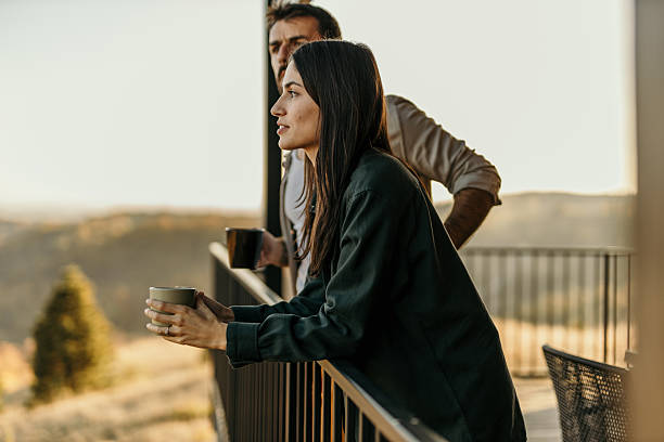 istock Couple enjoying morning coffee with a scenic view from balcony 2214752423