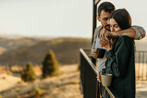 istock Romantic couple enjoying morning coffee on balcony with scenic view 2214752466