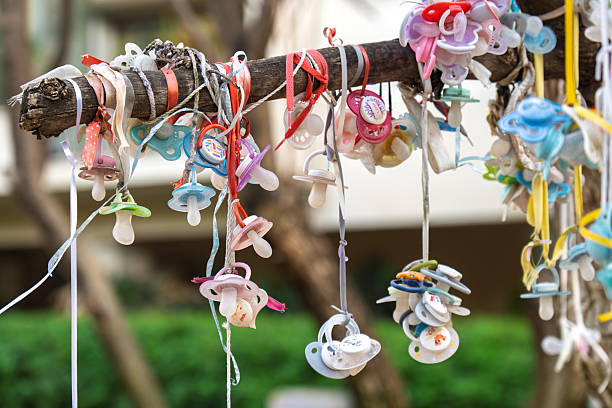 istock Colorful pacifiers tied on tree branch tradition 2214754582