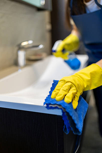 istock Cleaning a sink using gloves and cloth in a modern bathroom by a diligent person during daylight hours 2214758963
