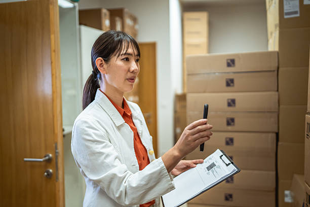 istock japanese woman scan boxes and clipboard in pharmaceutical warehouse 2214760128