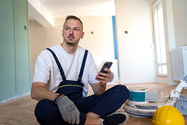 istock Young handsome man sanding and polishing wooden floor 2214761936