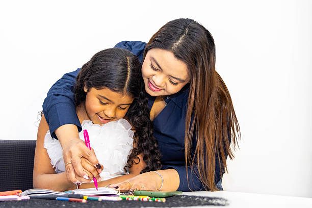 istock Latin mother helping daughter drawing with colored pencils 2214762234