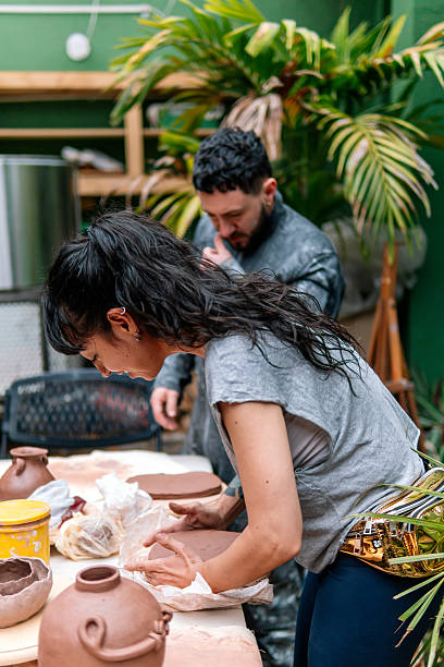 istock Woman making pottery with clay in workshop with colleague 2214766506