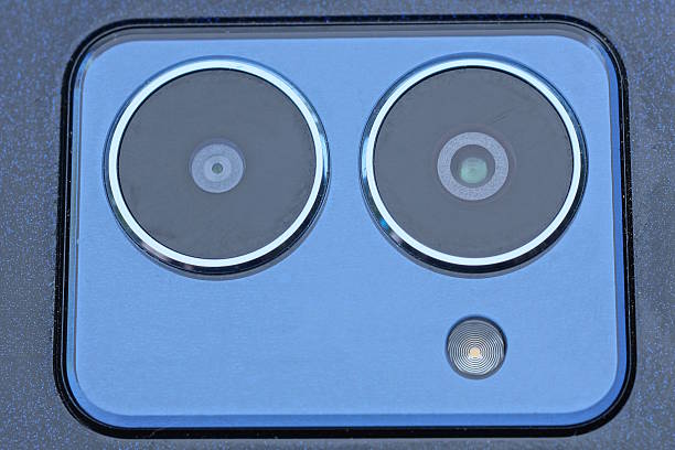 two gray blue camera lenses under glass on a black panel
