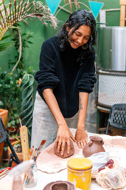 istock Smiling craftswoman molding clay in her workshop 2214766812