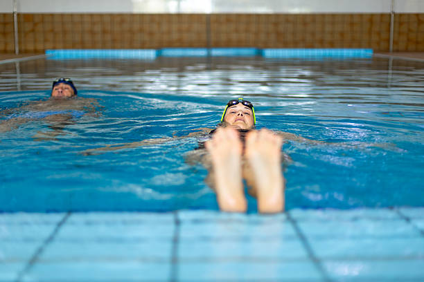 Young female swimmer resting at the edge of the pool after training
