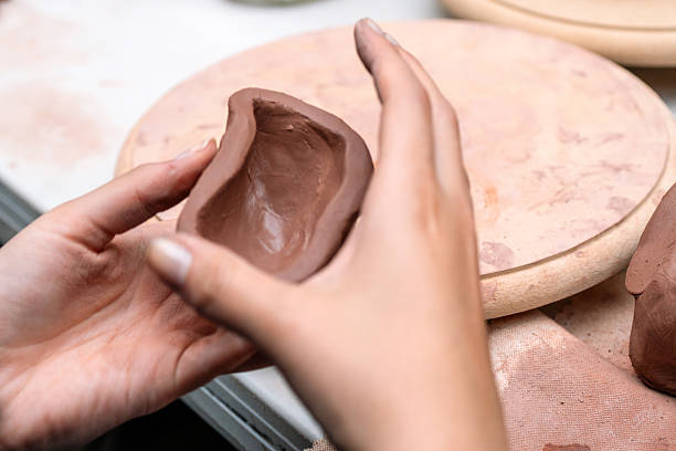 istock Potter molding clay creating a small bowl in workshop 2214767448