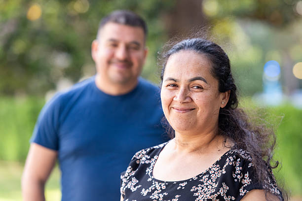 istock Smiling hispanic mature couple posing at a park looking at the camera 2214767684