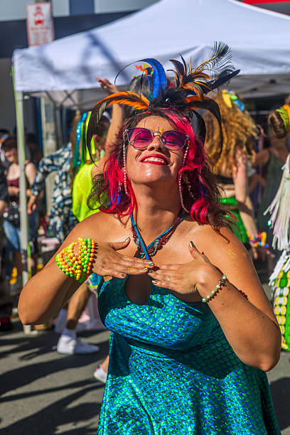 Wellington, New Zealand - March 02, 2025: A smiling performer in a vibrant outfit and feathered headpiece dances joyfully during Newtown Market festival in Wellington, New Zealand