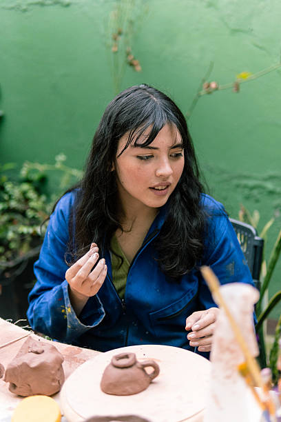 istock Young woman creating pottery tea cup outdoors 2214770272