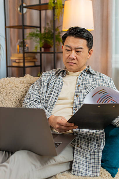 istock Stressed man freelancer feeling worried about financial problem doing paperwork sitting on sofa 2214771307