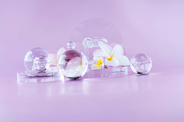 Aesthetic arrangement of cosmetic elements with glass spheres and floral accents on a soft background