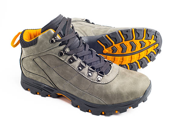 pair of gray leather hiking boots with yellow soles on white