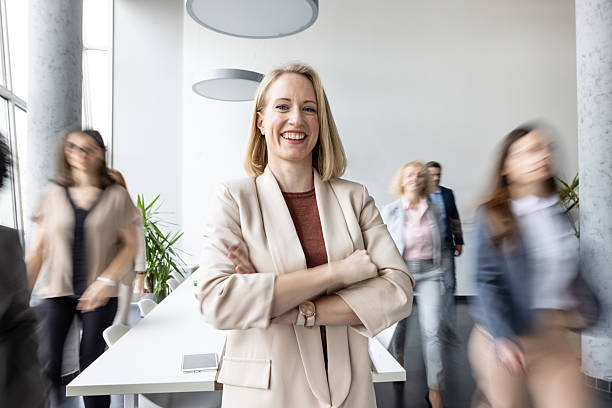 istock Businesswoman Smiling in Dynamic Office with Team Flowing 2214771407
