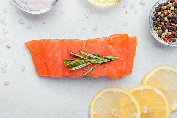 istock Fresh salmon fillet prepared with herbs and lemon slices for cooking 2214771982