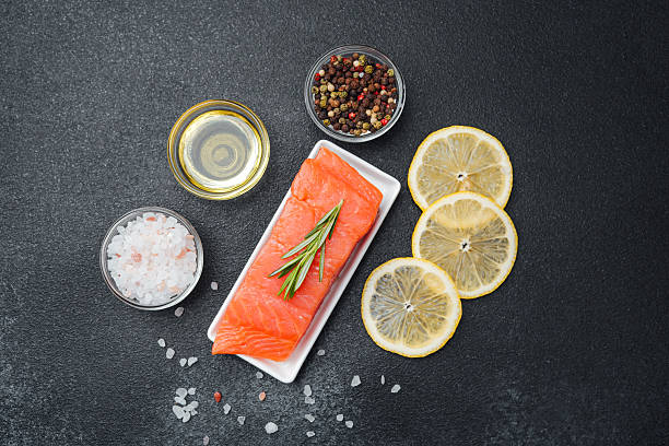 istock Fresh salmon fillet with lemon, herbs, and spices ready for cooking 2214771989