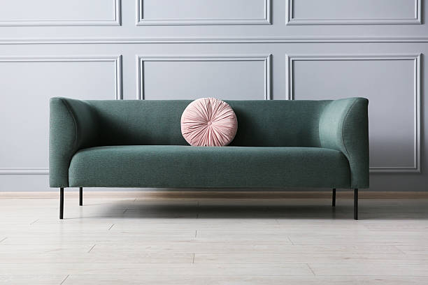 istock Stylish sofa with cushion near grey wall 2214772633